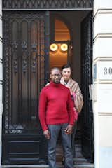 Udechuku and Smith stand in front of their neoclassical townhouse in Brussels. They met at law school in Australia (Smith is Australian, Udechuku is British) and together discovered their love of design while furnishing their homes over the years—in Australia, in London, in San Francisco, and later in Luxembourg. Today, clients come to them "for the breadth of our design knowledge, relentless pursuit of perfection for each client, and for our ability to research and source rare and unusual pieces," says Udechuku.  Photo 14 of 18 in A Neoclassical Gallery Home in Belgium