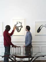 "People visit and they may well buy a specific chair but, more than anything, they appreciate the way we put the look together," says Udechuku, shown here with a client. "They often invite us to their homes and offices to consult on how to create an eclectic personalized look combining the type of pieces we have at home."  Photo 8 of 18 in A Neoclassical Gallery Home in Belgium