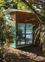 The Case Study–like structure is framed in timber and clad in alternating modules of stained plywood and colorful, semitransparent polycarbonate.