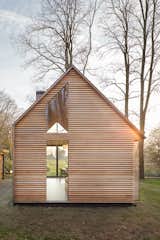 The house may appear conventional at a glance, but a closer look shows how Oostenbruggen has pushed the boundaries of the traditional gabled typology. It has an asymmetrical roof, with slate shingles that extend down the eastern side to close it off completely.
