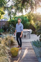 Outdoor, Garden, Walkways, Shrubs, Hardscapes, Gardens, Trees, Back Yard, Vertical Fences, Wall, and Wood Fences, Wall “I love the look of mass plantings,” notes Neely, near Mexican feather grasses--which thrive on the sunny lot.  Photos from Modern Furniture Fit for a Classic Eichler