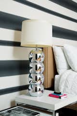 Mays chose Graham & Brown’s Verve Stripe wallpaper for the downstairs bedroom. The chrome lamp is vintage.