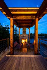 A covered fireplace and sitting area anchor the deck, which overlooks the water.