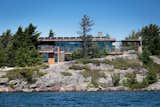 Though it is spacious and modern, Gane's cottage functions entirely off-the-grid. Sewage is treated on-site, water is filtered from the lake and cleansed with ultraviolet light, and an impressive solar array provides energy with battery storage.  Photo 5 of 11 in Monument Channel Cottage by Allie Weiss from Modern Meets Rugged at This Off-the-Grid Retreat in Ontario