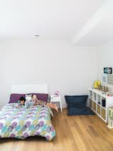 Bedroom, Bed, Shelves, Night Stands, and Storage The kids’ bedrooms are located on the second story. Karis’s room is furnished with a Fatboy beanbag chair.  Photo 7 of 11 in This Woodland Home in Virginia Was Built for Modern, Multigenerational Living