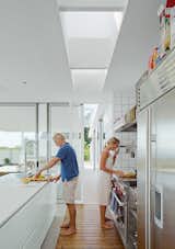 In the kitchen, the couple prepare a meal. The Multiform island is topped in Corian; the oven and hood is from Wolf.