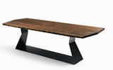 The Bedrock Plank A dining table by Terry Dwan for Riva1920 is made from solid walnut tree trunks with a raw iron base that maximizes under-the-table leg space. Price available upon request.