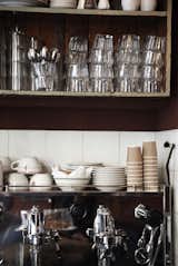 In the open kitchen, stacks of cups wait to be filled, machines wait to serve piping hot beverages, and spoons ready to stir. Photo by: Stine Christiansen