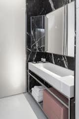 Nero Marquina marble defines the bathroom. The fixtures are Agape.