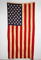 Paul’s American flag was a gift from one of his clients at the hair salon he owns. A flag should be fairly easy to procure at thrift stores or eBay, but this vintage stock from Urban Outfitters is a quick pick. $389