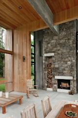 Choate selected maintenance-free materials for the project wherever possible, including the stone on this fireplace, which includes built-in storage for firewood. The stone extends 25 feet up to the wood-clad ceiling, emphasizing the home's grand scale.