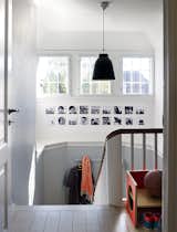 Staircase, Wood Railing, and Wood Tread In the Denmark home of designer Eglantine Charrier, original 1920s windows and moldings meet modern accessories like a black Caravaggio pendant lamp by Cecilie Manz for Lightyears.  Photo 1 of 12 in A Cramped Attic Became a Sunny Dining Room in this Renovation of a Copenhagen Tudor