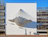 Commisioned by the city, Cradle by Ball-Nogues Studio hangs on a parking structure's exterior wall. Made up of polished and mirrored stainless steel spheres, the suspended sculpture is a marvel to see.