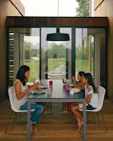 For the outdoor dining room, interior designer Damon Liss selected a Soho pendant lamp by Joan Gaspar, Trennza chairs from Janus et Cie, and the Portica outdoor table from Room & Board. The sliding glass doors are by Arcadia.