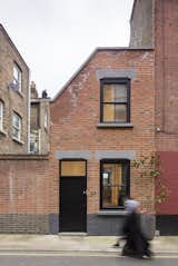 Set in a conservation area, the home’s façade was designed to blend into the street’s terrace style. To that end, it is clad in red bricks from Traditional Brick & Stone and punctuated with sash windows. The concrete toned lintels hint subtly at the modernity that lies within.  Photo 1 of 8 in Cleverly Stacked Floors Form a Roomy House On a Tight Lot by David Rudin