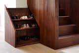 The base of the stairwell includes a hidden compartment to conveniently store shoes.