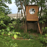 Climb into this snug tree house and watch the world from the inside, through the modern, circular window.&nbsp;