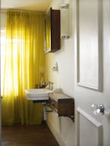 The cupboards of this bathroom are faced in panels of heavily aged leather, originally used on shelves in The British Library.  Photo 9 of 12 in A Gracious London Terrace House Is Reborn with Salvaged Materials
