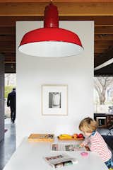 This bright red vintage pendant is perfectly centered over the dining room table, rather than to the center of the room.