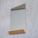 Designed by Andrea Stemmer for SCP, the Jules Mirror is an unframed, rectangular portrait mirror that works well in a small-profile bathroom. The mirror features a solid oak storage shelf at its base, which can be used to hold small items including makeup, toiletries, or even favorite photographs and postcards. The shelf is made from a single piece of wood and is shaped like a half pipe, which counters the rigid straight lines of the mirror with a warm curvature.
