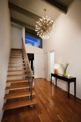 In the entryway, a brass Sputnik chandelier illuminates the airy American elm staircase.