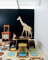 Kids Room, Bedroom Room Type, Rug Floor, and Pre-Teen Age Jennifer and Mattias Segerholt selected a deeply saturated blue hue color for the playroom wall inside their Portland, Oregon, home. All the interior walls are painted with matched hues from Le Corbusier’s Polychromie Architecturale, a book that the pair pored over for months. Photo by John Clark.  Photos from Chalkboard Walls in Kitchens and Kids' Rooms
