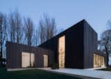 “We wanted the wood to appear as natural as possible, so leaving the larch untreated was the first choice,” Bas explained. But the shape of the house would make the wood turn gray unevenly, so they blackened the larch. “The clients were excited with the dark color as it helps the house blend into the trees. They didn’t want the anything excessive or showy.” But blackened timber comes with its own challenges. Since it absorbs more heat, a larger air cavity was built behind the wood to keep it cool.
