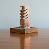"The etched copper of this model resembles the mashrabiya of traditional Arabian architecture for good reason: The model represents an early stage of the Nozul hotel that will overlook the Persian Gulf in Doha. The design responds to local climate as well as cultural history, as evidenced by the underlying, assemblage-like form. By eroding this mass, SOM created deep terraces that shade occupants and interiors from the beating sun. This strategy also maximized the height of the tower on a low-floor-area-ratio site. Here the core structure was made by 3D printing, and currently the real-life 55,000-square-meter building is in design development."