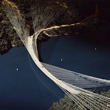 "In 1978, SOM architect Myron Goldsmith and engineer T.Y. Lin created a remarkable structure to span the challenging middle fork of California’s American River. Ruck-A-Chucky Bridge elegantly solves the problem of building a stable, economical structure across a wide, steep gorge by entirely rethinking the principles of bridge building. A “hanging arc,” the bridge was to be suspended by 80 high-strength cables and balanced by tensile forces. Though unbuilt, Ruck-A-Chucky Bridge stands as a masterwork of innovative design and structural economy to this day."
