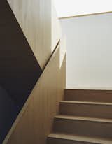 Wood is used throughout the home, as in a sculptural staircase designed by TACT.