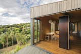 The plywood-lined communal area is flanked by separate units that contain matching bedrooms.  Photo 6 of 12 in Indoor-Outdoor Prefabs by Luke Hopping