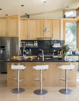 Kitchen, Wood Cabinet, and Refrigerator Pam stools from Ligne Roset pull up to the kitchen island; the custom birch cabinetry complements a Caesarstone Raven countertop.  Photo 3 of 14 in A Homeowner Uses Smart Technology to Manage His Napa Property from Anywhere