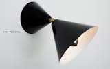 Handmade in Germany, the powder coated metal Cone wall and ceiling lamp consists of two black cones that are connected via a joint, allowing the larger version to be move freely.