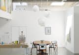 In Toronto, painter Kent Monkman created an airy artistic haven with both working and living quarters for a more balanced and polished picture. Inside, white paint lightens up the middle of the building. A vintage Danish dining set and Cloud pendants by Frank Gehry for Vitra define the dining area. Photo by Matthew Williams.