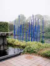 Cobalt glass spears by Seattle artist Dale Chihuly reside in the pond beside the main house. Larsen is both friend and patron to Chihuly, and the two were introduced when the latter was studying interior architecture and weaving. Larsen recalls in his memoir, "When we met, [Chihuly] was heating strips of glass sufficiently to bend them over and under to form an interlaced plane. I suggested he learn glassblowing with Harvey Littleton, the father of modern glass, who had been a prolific potter when I was at Cranbrook." Chihuly then went to Madison, Wisconsin, to study under Littleton, and he then started a school in the Northwest with $2,000 in prize money—now Pilchuck Glass School.