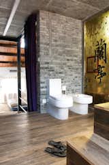 Bath Room, Medium Hardwood Floor, and One Piece Toilet A yellow glass panel divides the shower from the toilet and the bidet.  Photo 9 of 11 in Modern Lilong House Renovation in Shanghai