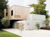 Designers Christopher Robertson and Vivi Nguyen-Robertson conceived their house as an unfolding sequence of simple geometric forms: a low concrete wall, a concrete cube, and a boxclad in Siberian larch.