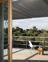 Outdoor, Wood Patio, Porch, Deck, Trees, Rooftop, Metal Fences, Wall, and Side Yard Automated shutters overhead provide privacy when closed and shade the deck when open.  Photo 2 of 9 in This Futuristic Prefab in Spain Has All the High-Tech Gizmos of a Spaceship