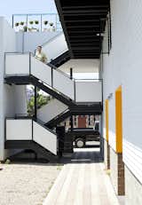 Staircase and Metal Railing "The simple volume of the space and large openings let light and air flow freely," Benson says. "The environment is always pleasant even without air conditioning or heating."  Photo 13 of 14 in San Diego Teaches Us How Micro-Living Can Thrive