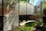 The west-facing exterior side wall is covered with an aluminum lattice rainscreen that controls sun pouring into the full-height windows beneath.