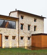 When Guido and Sabrina Chiavelli left their tiny apartment in Asolo to begin their family life in the northern Italian countryside, they chose to renovate a crumbling sandstone farmhouse. The desire to preserve the building's original structure while adding a modern aesthetic led the couple to augment the stone walls with teak panels and wide windows.