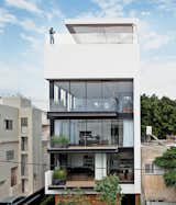Tall and surprisingly open, the Tel Aviv Town House by Pitsou Kedem Architects continues in the tradition of its Bauhaus-inspired neighbors with a white facade and black window frames.  Photo 1 of 1 in Modern Urban Living by Annie Januzzi-Thomas from Modern Courtyards Part Two 