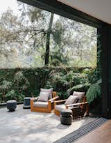 Designer Ezequiel Farca transformed a 1970s-style concrete home into a tranquil sanctuary in Mexico City. The temple-like retreat blends into the hilly Lomas de Chapultepec neighborhood with its pale green hue and strategic plantings, which soften the boundaries between house, garden, and street. The Recinto lava stone patio, which is accessed through the living room, holds teak outdoor furniture designed by Farca himself.&nbsp;