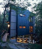 Scrap steel and reclaimed wood clad the three-story triangular tower, which hovers over a small deck and outdoor space. Photo by Paul Orenstein