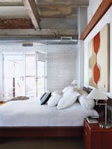 Like the communal spaces, the bedroom features a shining subway tile wall.