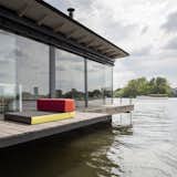 A wooden patio wraps around three-fourths of the house boat. The living room cushions can be removed and used on the deck. A ladder dips into the water for swimming in the summer.