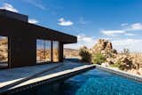 An unadorned black façade echoes the homeowners’ brief but compelling instructions to the architects to design a house like a shadow.  Photo 4 of 8 in A Sculptural Desert Escape Inspired by a Shadow