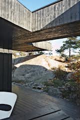 A section of the roof reaches over a rock outcropping—a detail that visually connects the house to the landscape and offers a handy way to climb up to the roof deck without using a ladder.