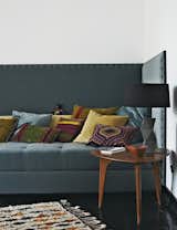 Fehrentz designed the sofa and had it upholstered in fabric by JAB Anstoetz. He cast the concrete base of the table lamp. The 1950s teak coffee table is vintage.  Photo 7 of 11 in Inside Peter Fehrentz's Renovated Flat in Berlin