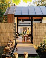To reference the original structure and to offer privacy, Grizzle left two of the shingled walls standing. The building, accessed by a cedar deck, opens to its surroundings via a sliding glass wall by Fleetwood and a bifold steel-and-glass garage door from Wilson Doors.